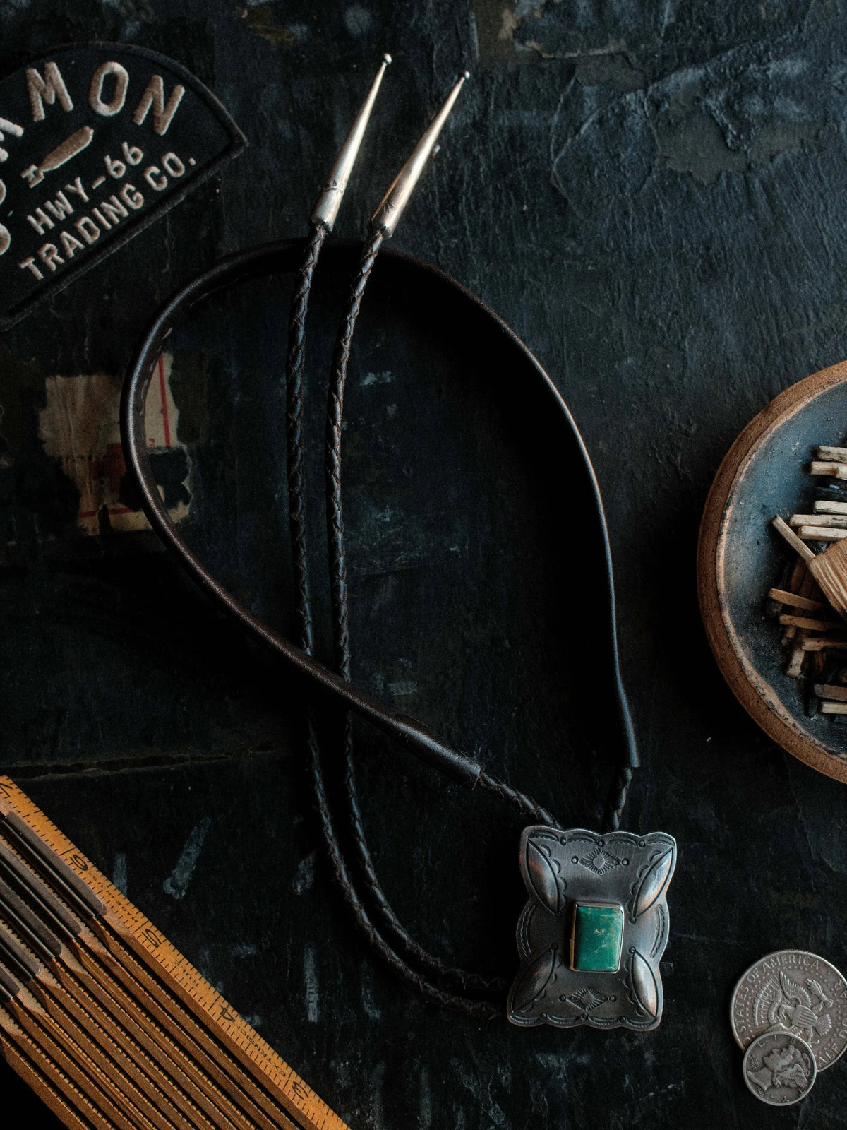 Royston turquoise from Nevada, hand-stamped with bump-outs for dimension, on a braided leather cord with sterling tips.