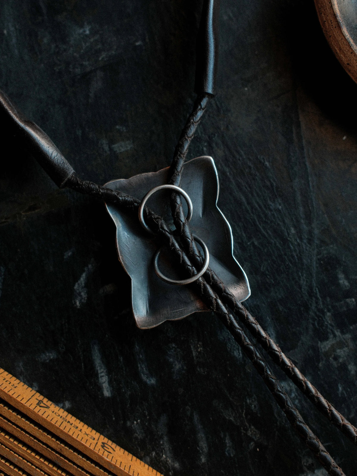 Royston turquoise from Nevada, hand-stamped with bump-outs for dimension, on a braided leather cord with sterling tips. — view 3