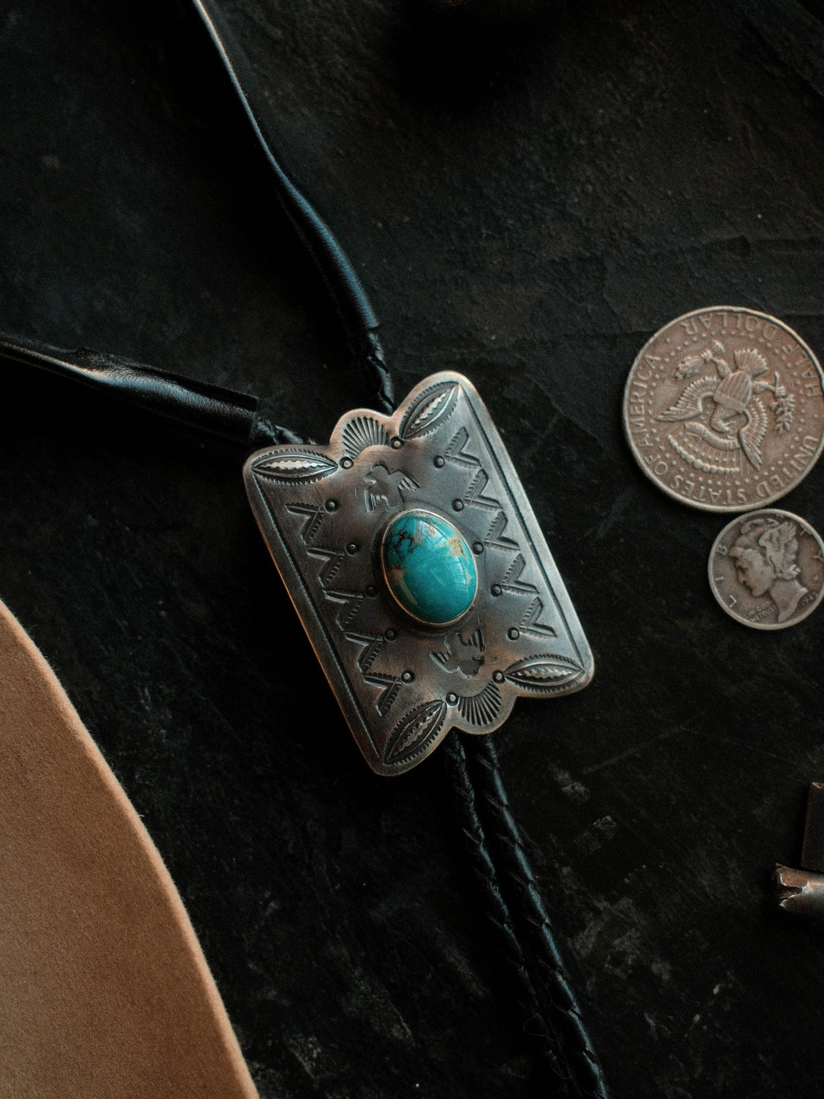 Royston turquoise from Nevada, hand-stamped with bump-outs for dimension, on a braided leather cord with sterling tips.