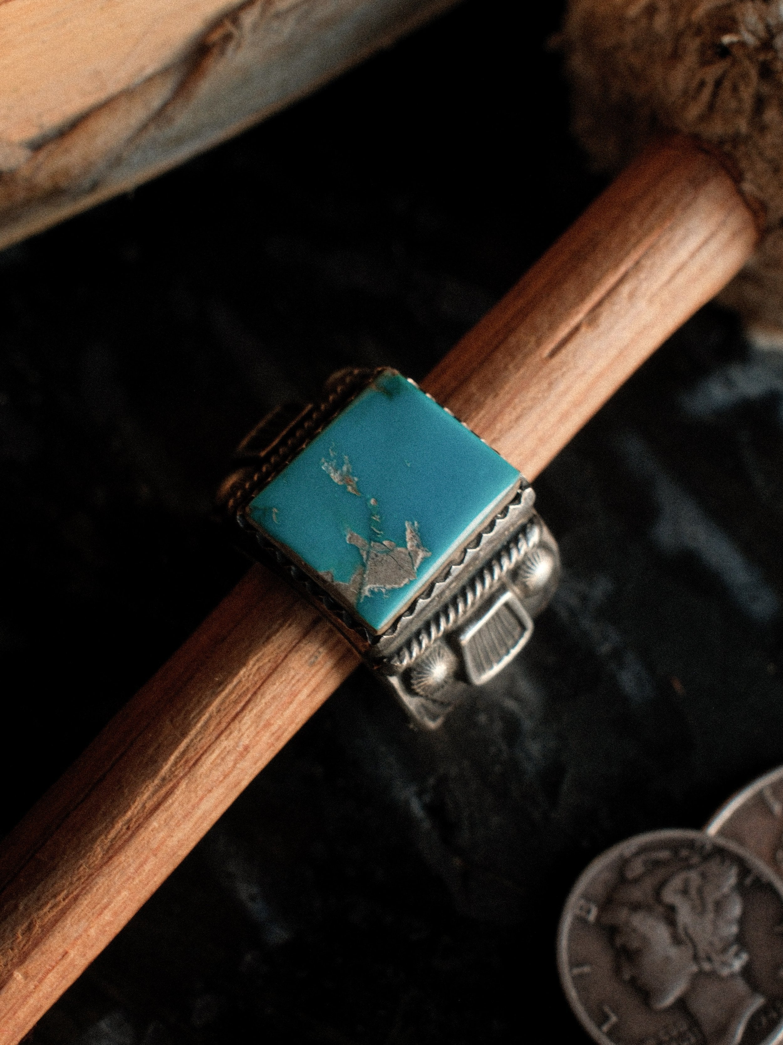 Kingman turquoise in a hand-filed serrated bezel on a tiered sterling base, hand-stamped