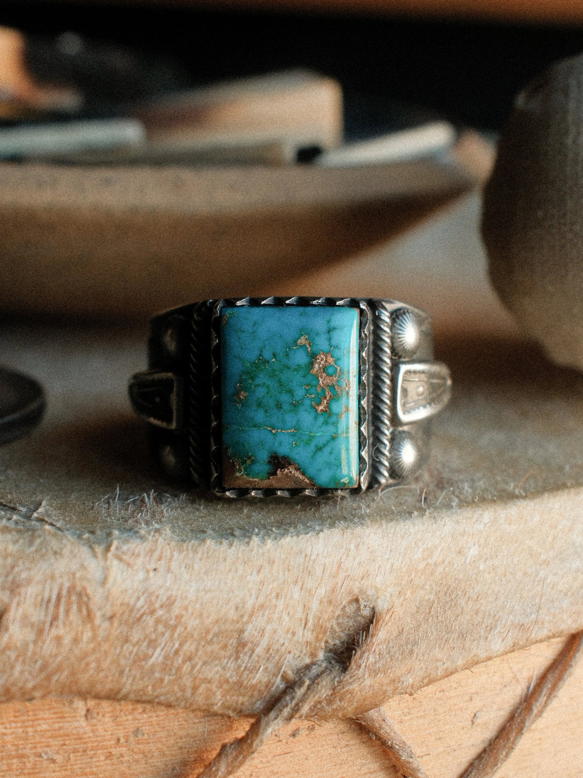 Kingman turquoise held in a hand-filed serrated bezel over a tiered, hand-stamped base