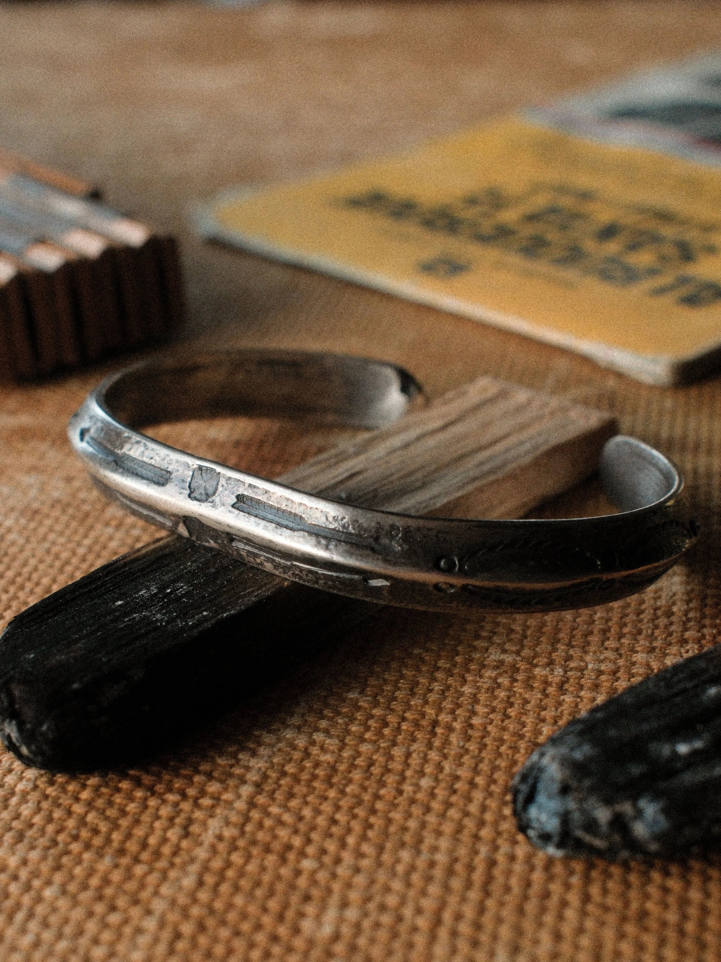 A one-of-a-kind triangle cuff formed from a tufa-cast sterling ingot, hand-stamped — view 2