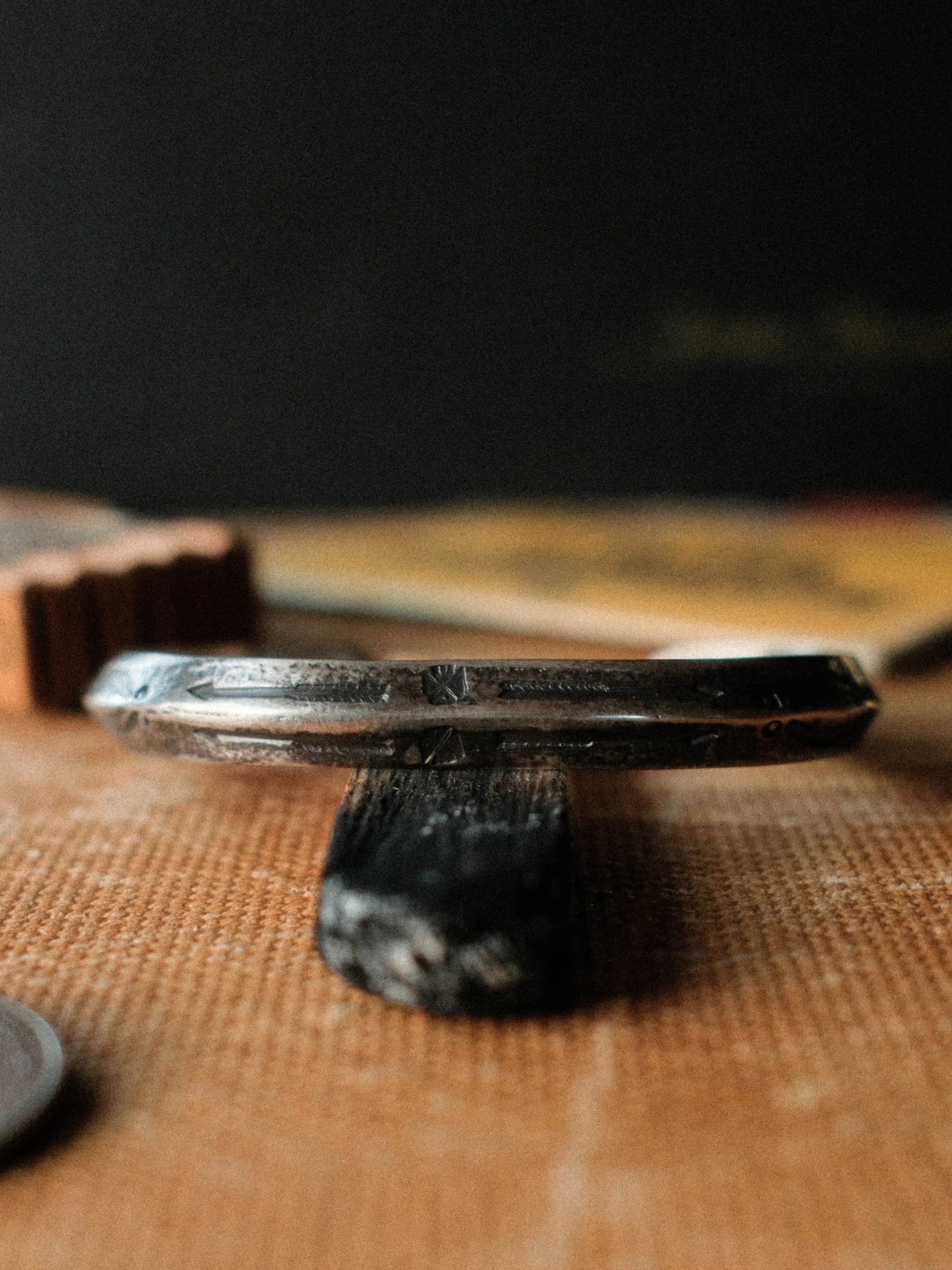 A one-of-a-kind triangle cuff formed from a tufa-cast sterling ingot, hand-stamped