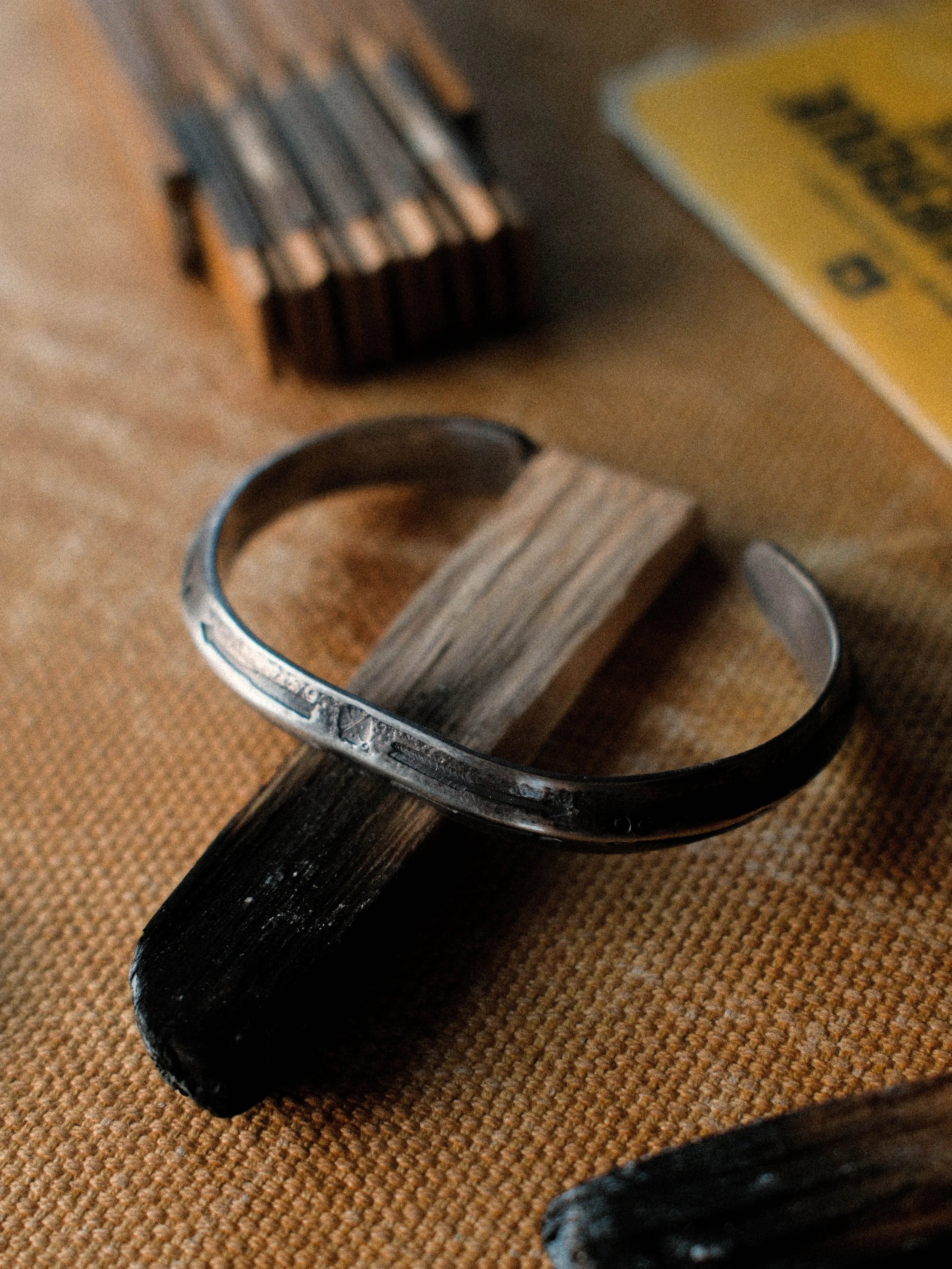 A one-of-a-kind triangle cuff formed from a tufa-cast sterling ingot, hand-stamped — view 3