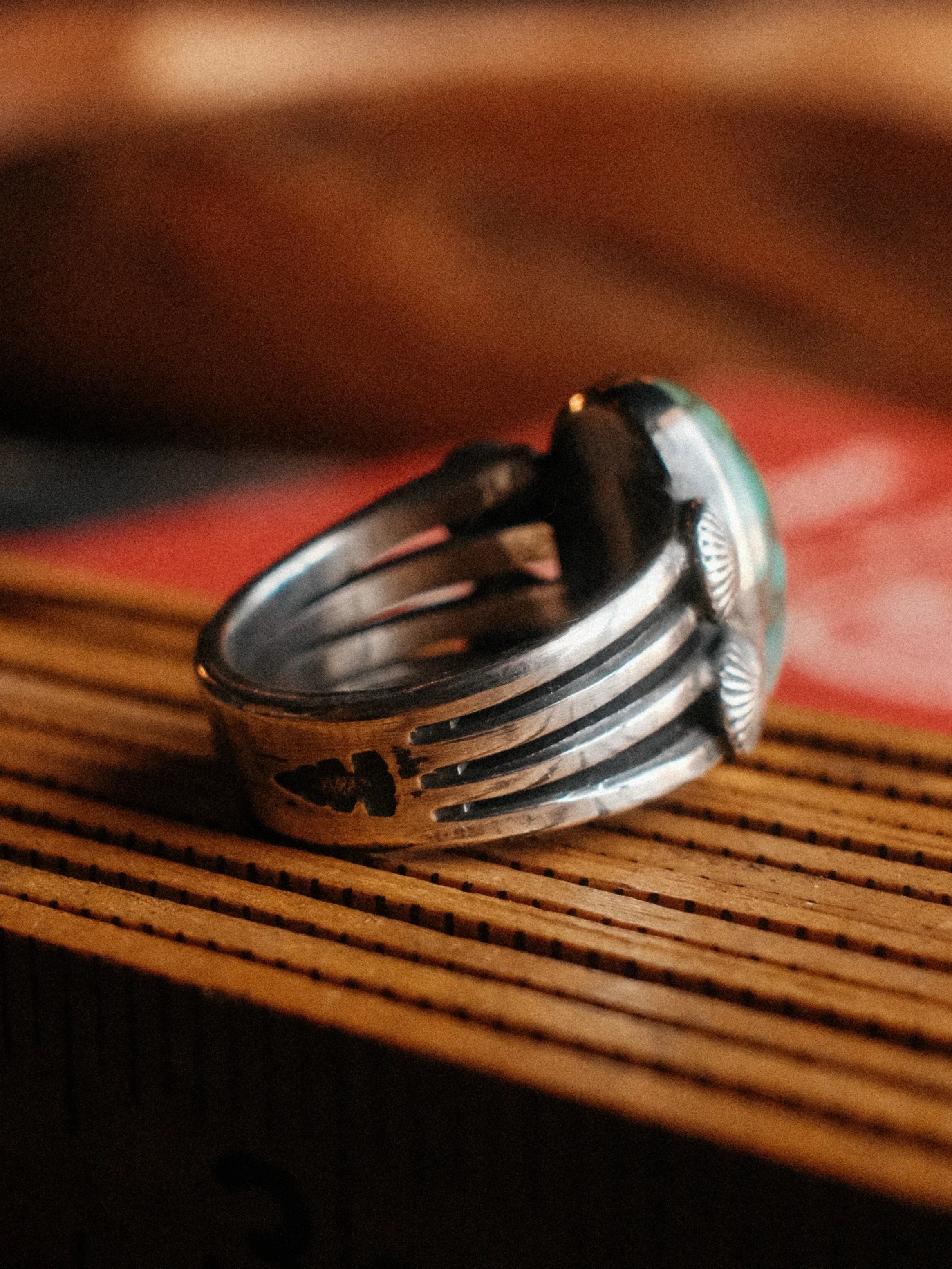 A premium 16×10mm Royston turquoise on a four-prong shank with sterling concho details, hand-stamped — view 3