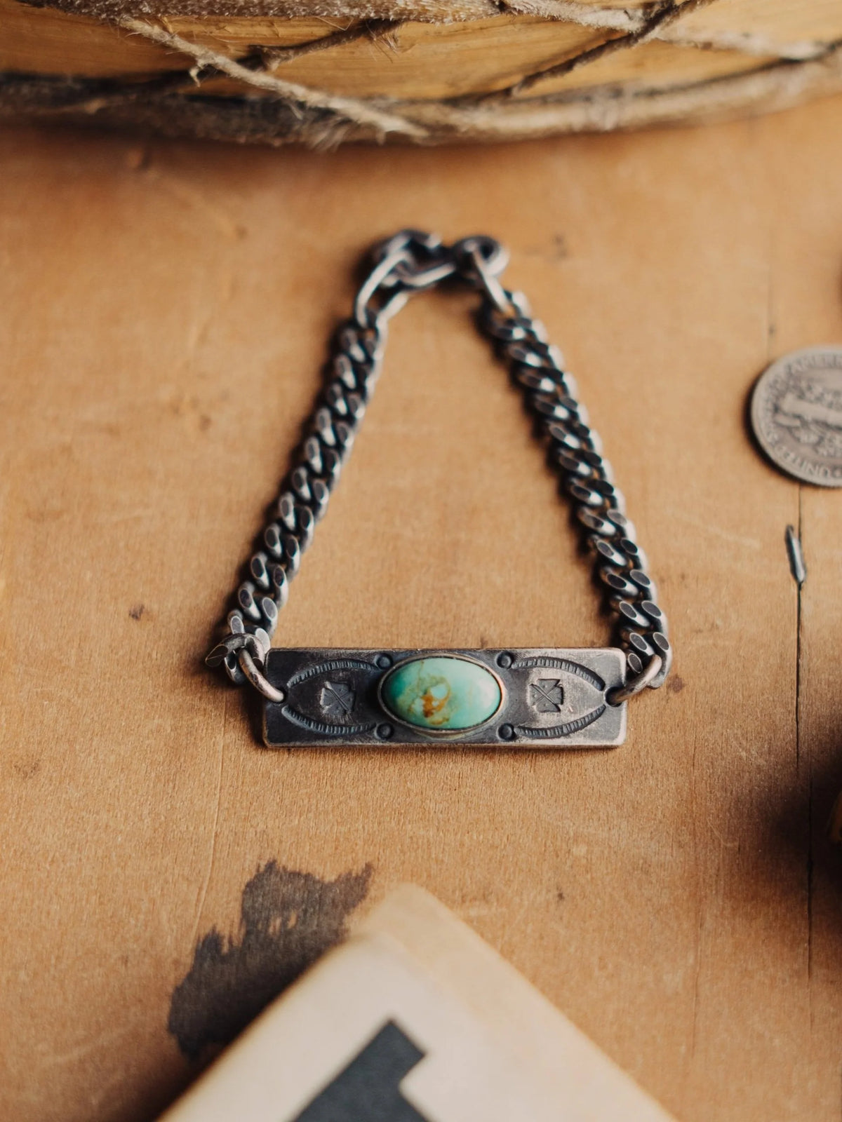 Manassa turquoise on a hand-stamped ID plate and sterling chain, finished with an aged patina and sister-hook clasp