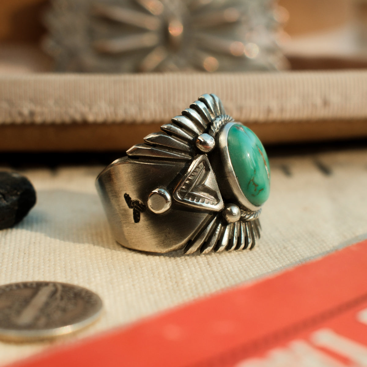 A one-of-a-kind 10×14mm Carico Lake turquoise in a smooth bezel, framed by hand-stamped rays and stamped triangular panels on a wide tapering band — view 2