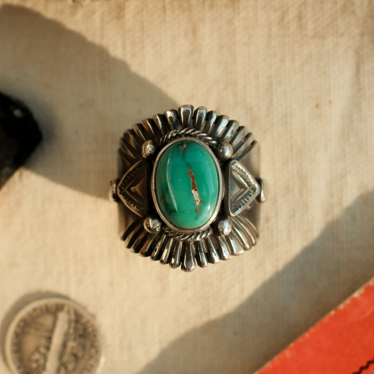 A one-of-a-kind 10×14mm Carico Lake turquoise in a smooth bezel, framed by hand-stamped rays and stamped triangular panels on a wide tapering band — view 4