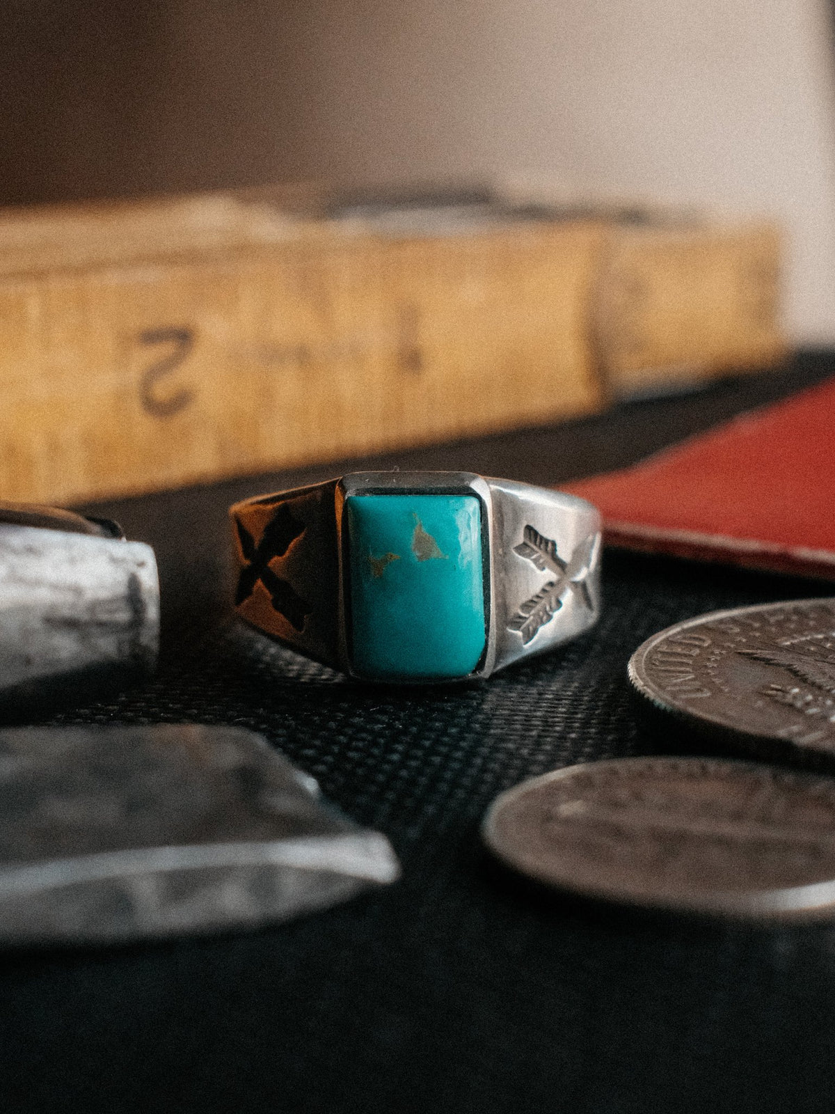 Crossed arrows struck by hand into sterling, centered on a piece of Manassa turquoise from Colorado's dormant King mine