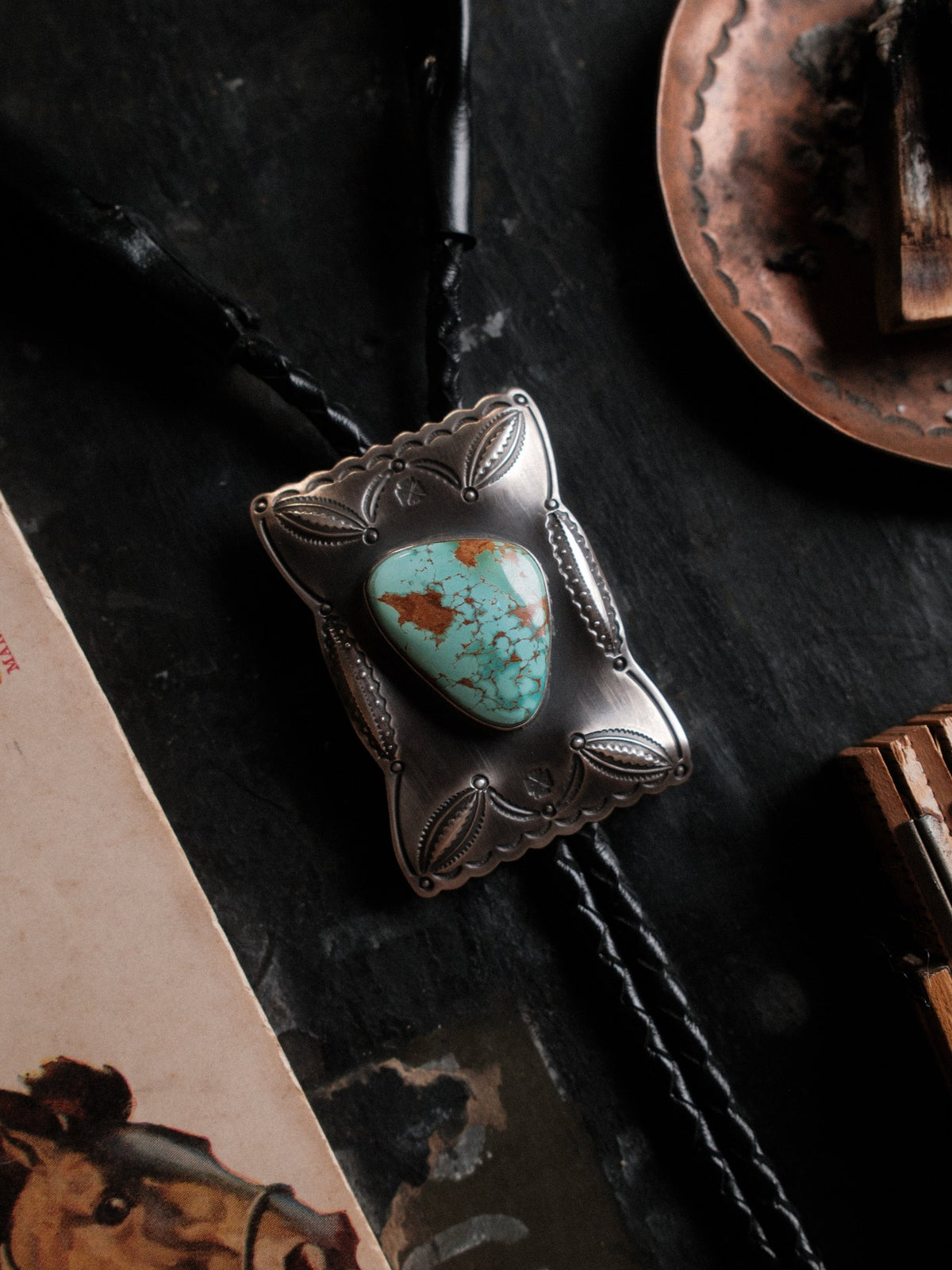 Royston turquoise from Nevada, hand-stamped with bump-outs for dimension and finished with sterling end tips on a braided leather cord