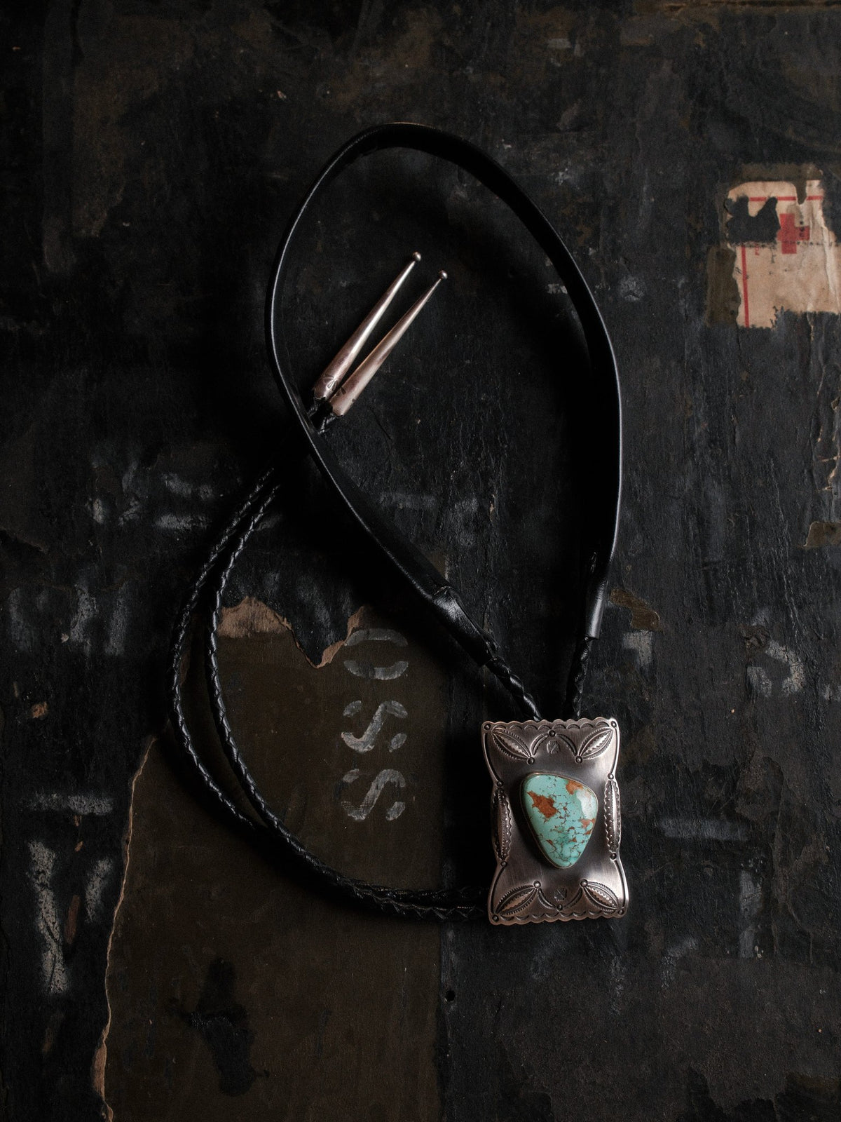 Royston turquoise from Nevada, hand-stamped with bump-outs for dimension and finished with sterling end tips on a braided leather cord — view 2