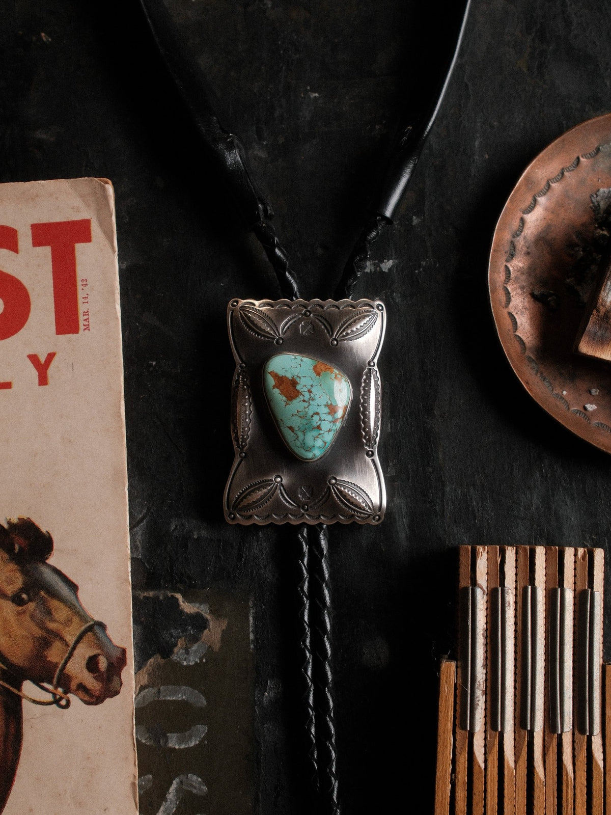 Royston turquoise from Nevada, hand-stamped with bump-outs for dimension and finished with sterling end tips on a braided leather cord — view 3