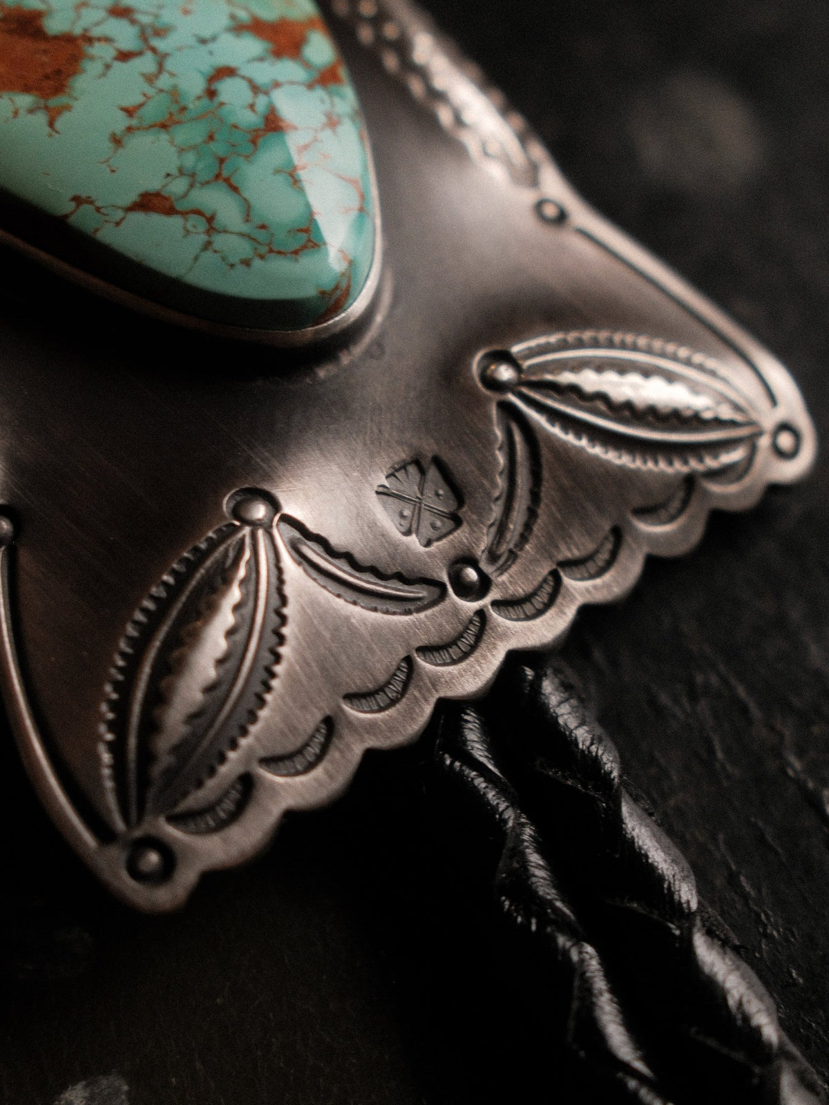 Royston turquoise from Nevada, hand-stamped with bump-outs for dimension and finished with sterling end tips on a braided leather cord — view 4