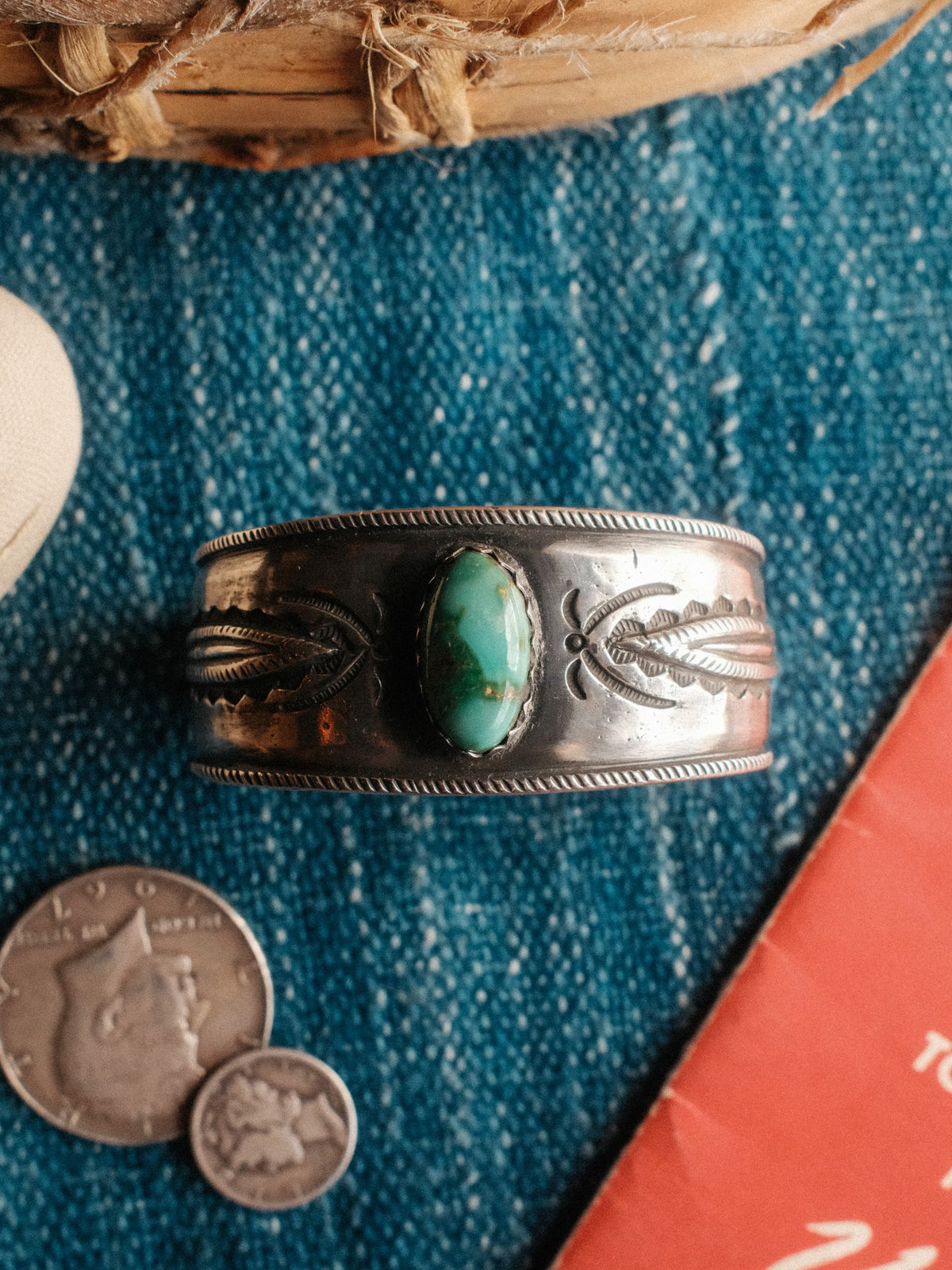 A tufa-cast ingot cuff set with Royston turquoise and hand-stamped with Chad's own steel