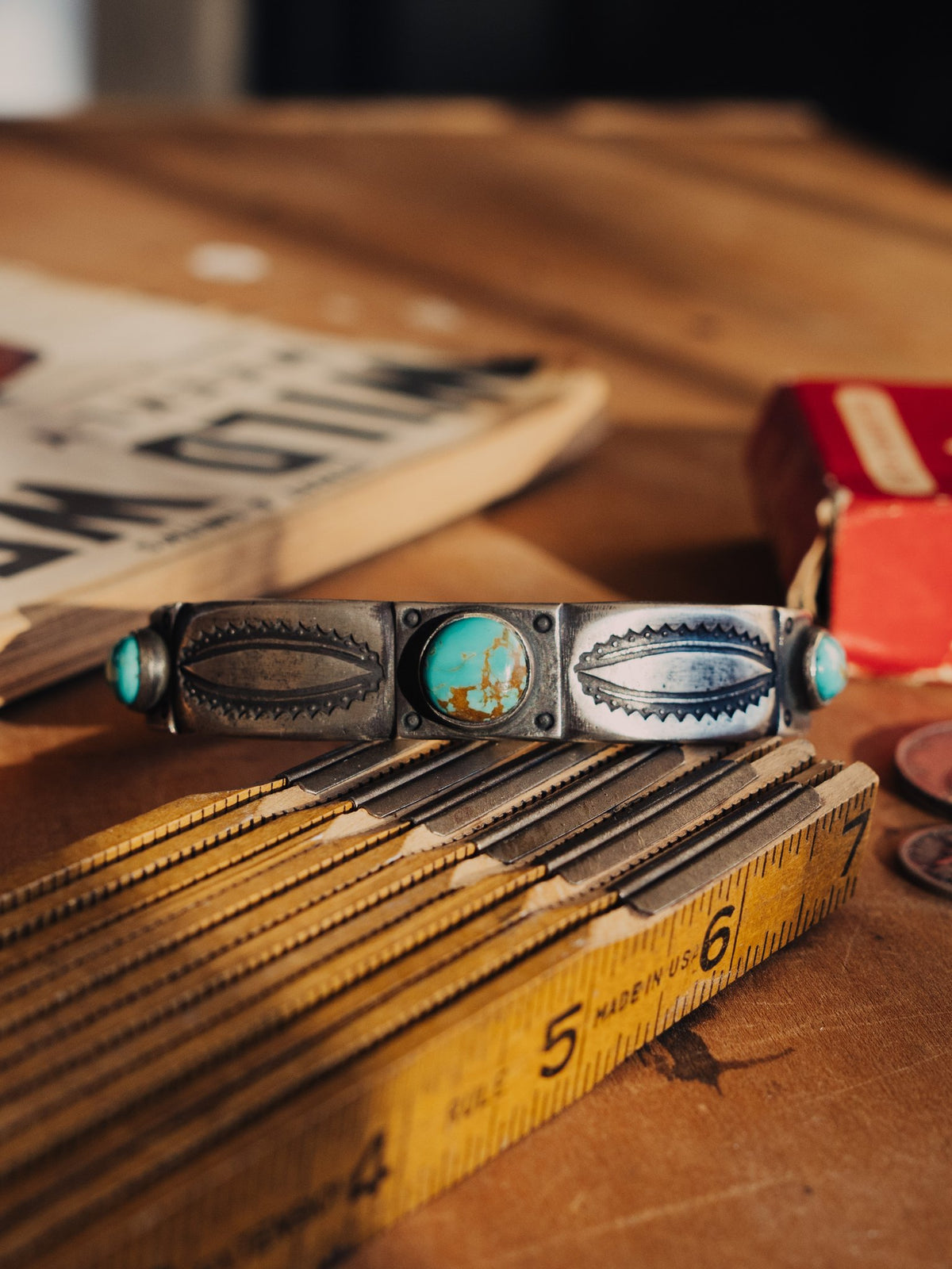 Formed from a tufa-cast ingot and set with three premium stones of Manassa turquoise from our private collection, intricately stamped with our collection of handmade steel stamps