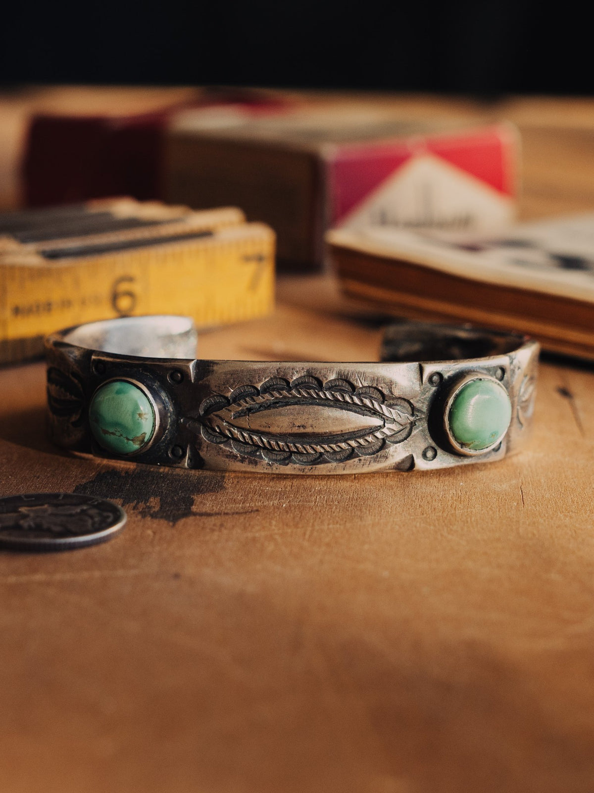 A tufa-cast ingot cuff, intricately hand-stamped and set with two premium pieces of Manassa turquoise from Colorado's dormant King mine